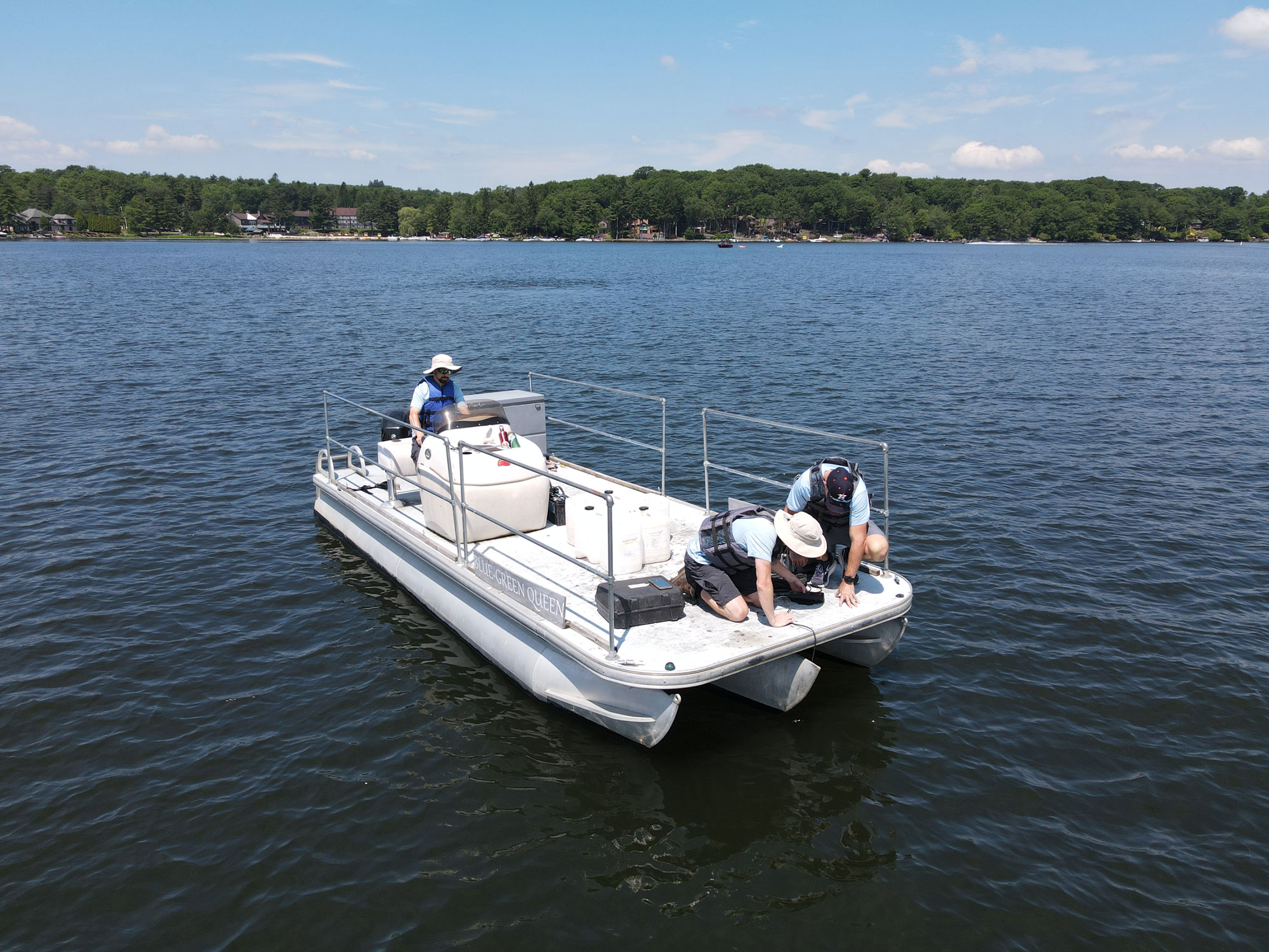 technicians in boat taking an oxygen sample on Lake